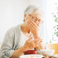食事中にむせる高齢女性