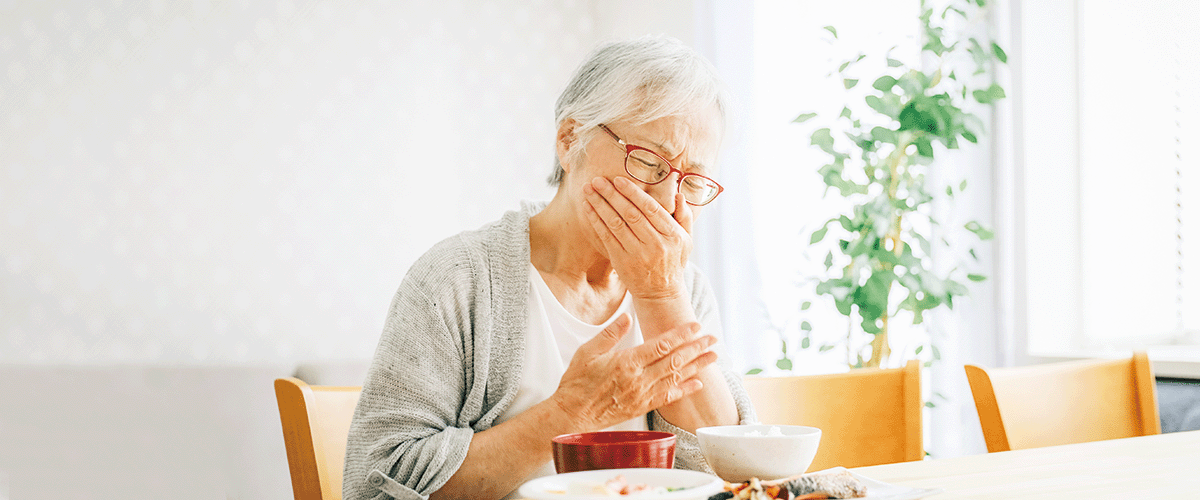 食事中にむせる高齢女性
